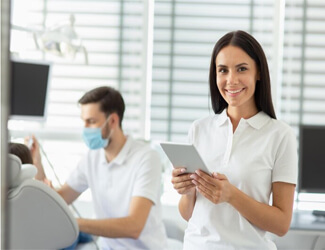 Picture of a young dental assistant smiling back at the camera