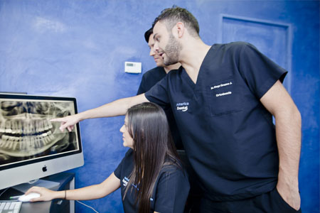 Close up picture of three dentists looking at the computer screen