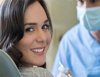 Picture of a woman at her dental appointment smiling back at the camera