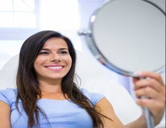 Picture of a woman holding a mirror and smiling